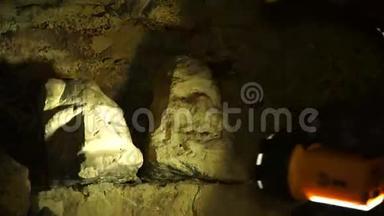 地下研究人员在地下隧道中攀爬。 从石头旁经过。