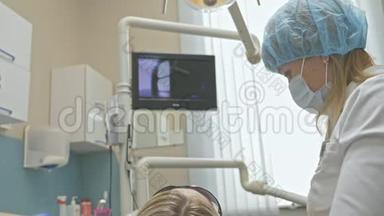 医生用特殊的口腔检查数字微相机检查牙齿。 监控牙医和病人看录像