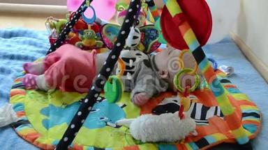 新生儿可爱的宝宝在五颜六色的发育垫上玩玩具