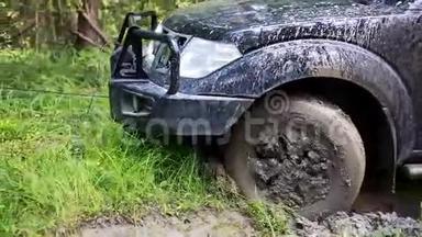 黑色越野车被困在森林里的泥里，越野