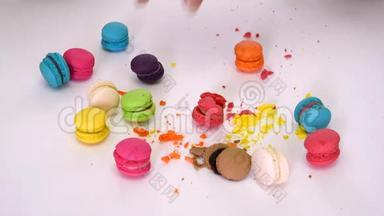 特写一个女人的手拿起凌乱的五颜六色的通心粉（通心粉）糖果甜点，它是粉碎和挤压的小碎片
