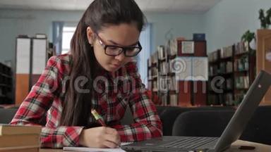 留着长发的女孩戴着眼镜在学校图书馆工作。