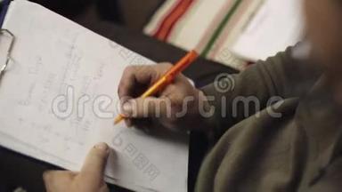 人坐在一张纸上，用中，用钢笔在文件夹中划线。 写作。