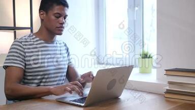 年轻的黑人因失去而心烦意乱，在笔记本电脑上工作