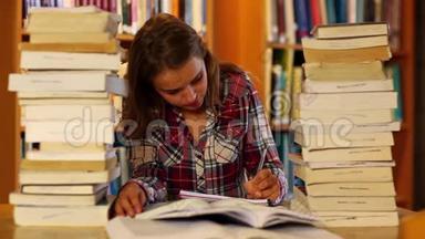 专心致志的学生在图书馆里学习和记笔记，周围是书