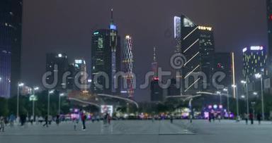 摩天大楼在晚上，广州在晚上，人们在城市里走来走去