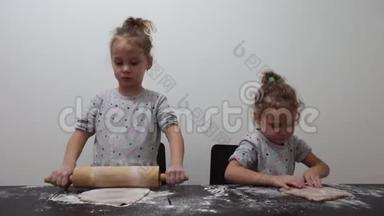 快乐的双胞胎女孩在厨房准备饼干，在现实生活中的休闲生活照片，圣诞饼干