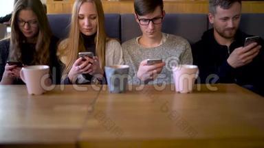 一群人在咖啡馆里使用手机，<strong>而不是</strong>互相交流