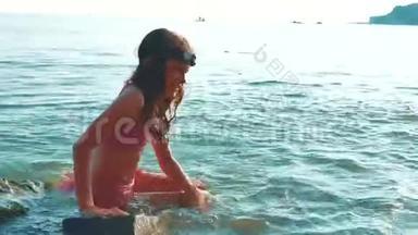 小女孩用石头和石头在海里洗澡。 少女生活方式女儿在海浪中游泳