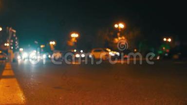 城市的夜间交通。在夜间道路上开有灯的散焦汽车。