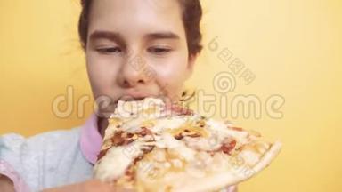 快乐的小女孩吃一片<strong>披萨</strong>的概念。 十几岁的孩子饿了吃一片<strong>披萨</strong>。 慢动作视频。 <strong>披萨饼</strong>