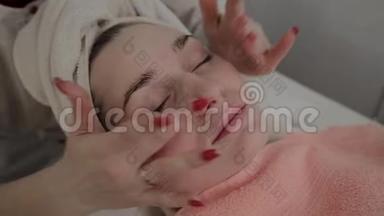 一位专业的美容师在敷面膜之前做面部按摩。 美容学的新概念。