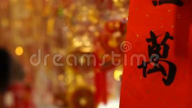 挂着中国新年装饰品的商店。 五颜六色的红色，金色和漂亮的文字装饰吊坠和纸周围