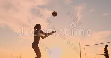 在一个美丽的夏日傍晚，运动女孩在沙滩排球比赛中跳到空中，在网上击球