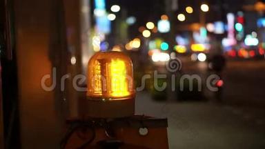 城市交通模糊背景下夜间工地施工警示灯闪烁。