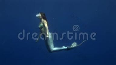 年轻<strong>女孩</strong>在红海的蓝色背景上模特水下美人鱼服装。