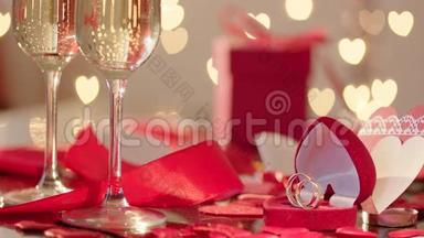 缓慢的玫瑰花瓣雨<strong>落在</strong>结婚戒指和<strong>装满</strong>香槟的眼镜上