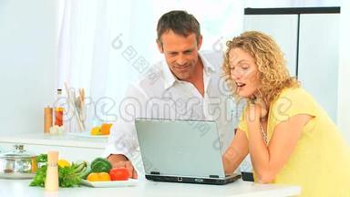 可爱的一对夫妇在网上看菜谱