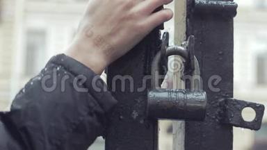 在雨中站在铁门旁等候的年轻人，要紧紧抓住他的手