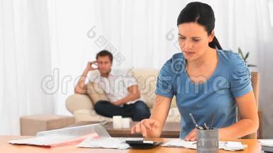 当男朋友在沙发上的时候，女人在计算账单
