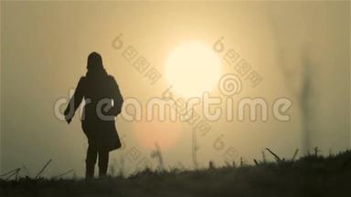 年轻女孩遇见新的一天。 女人跑步，黎明时散步。 黎明的女孩在太阳的圆圈里。