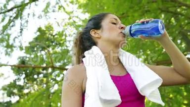 在公园锻炼后，女人擦了擦眉头和喝水