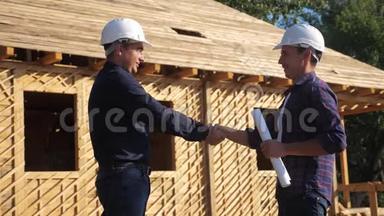 团队合作握手。 概念建设构建建筑师慢动作视频。 两个戴头盔的人握手