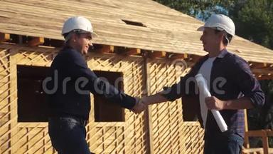 团队合作握手。 概念建设构建建筑师慢动作视频。 两个戴头盔的人握手