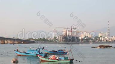 在黎明时分，渔船在河上与建设度假城市对峙