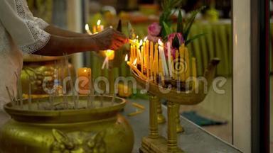 佛日在佛寺。 人们点燃蜡烛、鲜花和香棒。 沃特纳哈拉姆，普吉，泰国。 慢慢