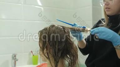 女理发师在家里的浴室里给一个年轻女人的头发涂上<strong>油漆</strong>，用<strong>刷子</strong>涂上<strong>油漆</strong>
