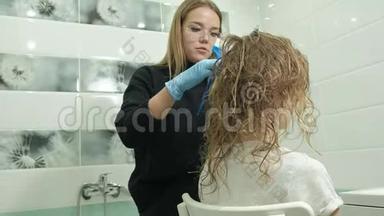 女理发师在家里的浴室里给一个年轻女人的头发涂上<strong>油漆</strong>，用刷子涂上<strong>油漆</strong>