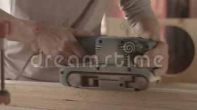 木工用砂带打磨机仔细加工木板表面。