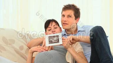 年轻夫妇在看他们未来孩子的扫描图