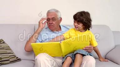 老人和孙子坐在沙发上看相册