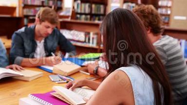 <strong>学生</strong>们<strong>一起</strong>在图书馆工作，女孩对着镜头微笑