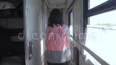 十几岁的女孩带着背包在火车车厢里散步。 交通运输铁路概念小女孩走路