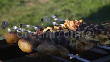 烤串上的烤串和土豆在烤炉里的煤上煮熟。