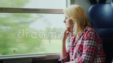 一个年轻的女人正在火车上旅行。 <strong>望</strong>着<strong>窗外</strong>