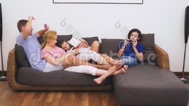 可爱的家人，妈妈，爸爸，女儿和儿子一起在客厅看电视，每个人都在看他的电视
