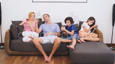 可爱的家人，妈妈，爸爸，女儿和儿子一起在客厅看电视，每个人都在看他的电视