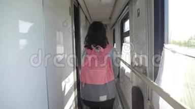 十几岁的女孩带着背包在<strong>火车车厢</strong>里散步。 旅游运输铁路概念。 小女孩走路