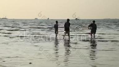 三个人沿着浅海的天空，微风，<strong>潮起</strong>潮落的海岸线，夕阳