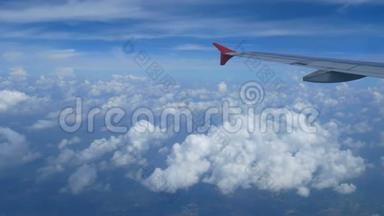 4K镜头。 乘飞机旅行。 透过飞机窗户的鸟瞰。 蓝天上美丽的白云