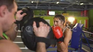 年轻女子拳击手与她的教练在拳击场训练<strong>赛前</strong>热身