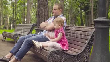 <strong>爸爸</strong>和小女孩坐在长凳上