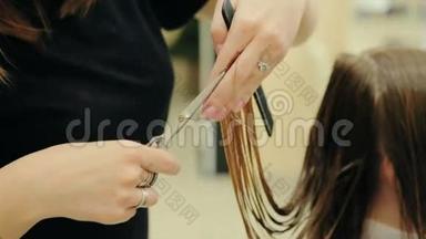 女理发师手握手指间锁毛，梳子和剪刀特写.. 用剪刀修剪头发的尖端。 圣斯特