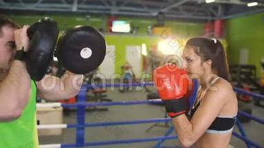 年轻女子拳击手与她的教练在拳击场训练<strong>赛前</strong>热身