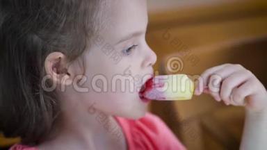 美丽的小女孩吃着美味的彩色冰淇淋