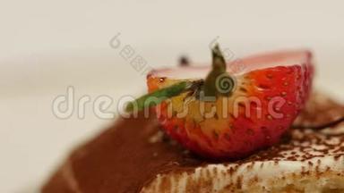 一片草莓放在白色的香草奶油里。 草莓切片贴紧.. 把草莓绉蛋糕切片